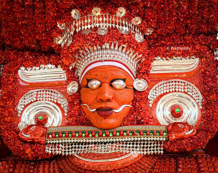 Close view of the Muchilottu Bhagavathi face painting, silver ornaments and thechi-flower mudi